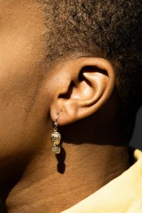 African American lady's ear. Why can't I hear yu God?