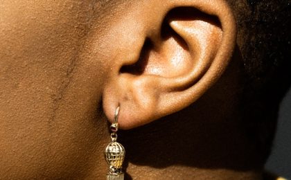 African American lady's ear. Why can't I hear yu God?