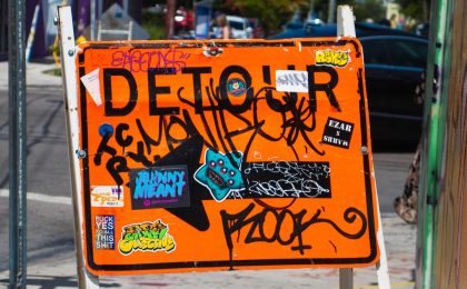 you can find destiny in your detour, detour sign with graffiti on it
