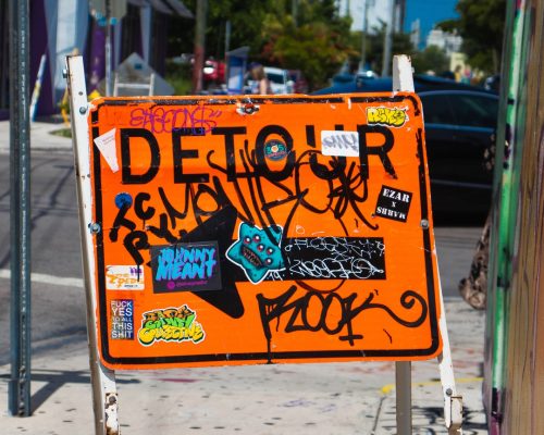 you can find destiny in your detour, detour sign with graffiti on it