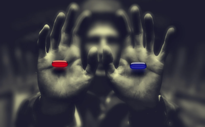 man holding a blue pill and a red pill, wake up and climb out of your coffin