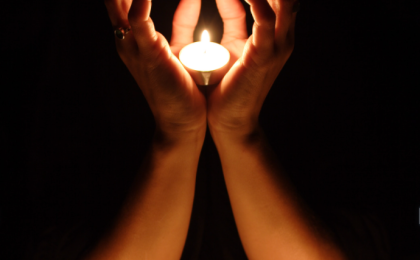 destined to shine: how to be a light in the dark, hands holding a light in the darkness